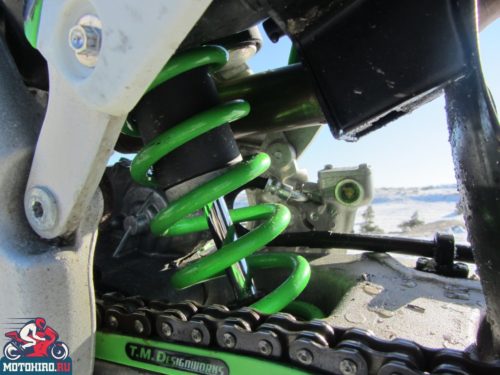 Зеленая пружина заднего моноамортизатора в подвеске мотоцикла Kawasaki KX450F