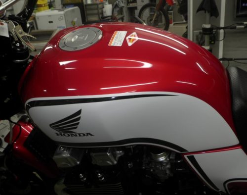 Красный бак с белой наклейкой на байке Honda CB 750