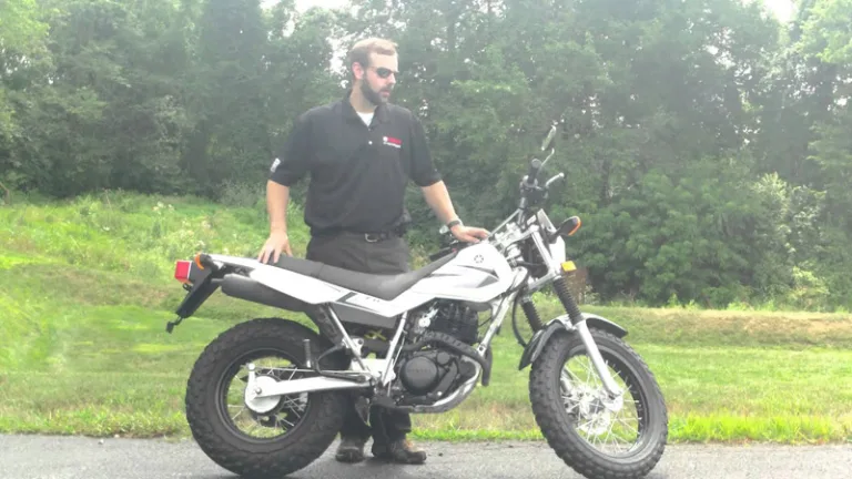 Yamaha TW 200 и человек рядом с ним для сравнения размеров