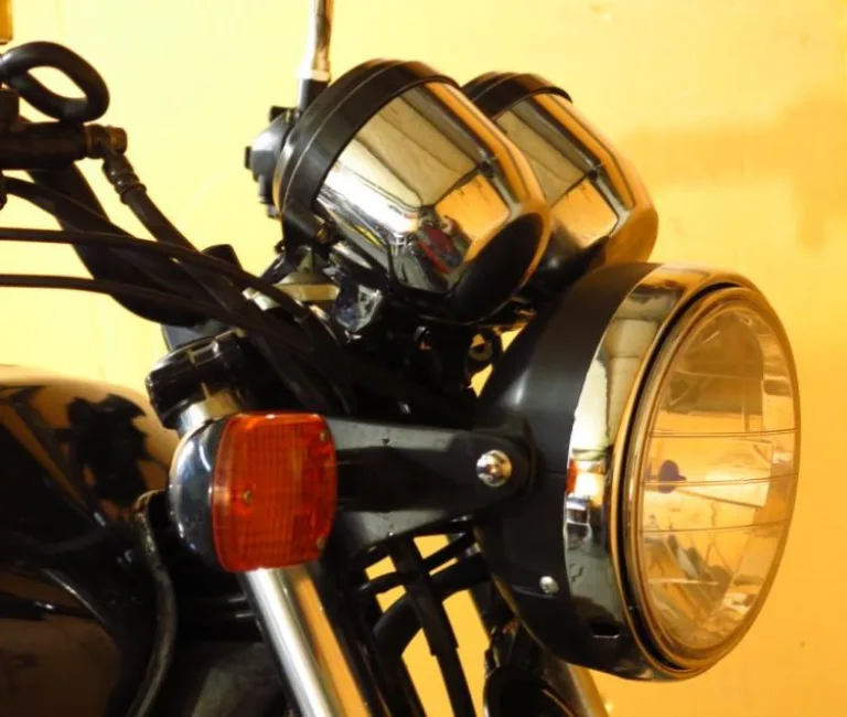 Круглая фара и желтый поворотник в передней части дорожного байка Honda CB 750