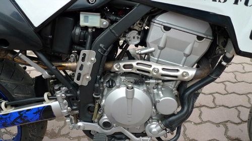 Фото двигателя с водяным охлаждением мотарда Kawasaki D Tracker 250, вид со стороны тормозной педали