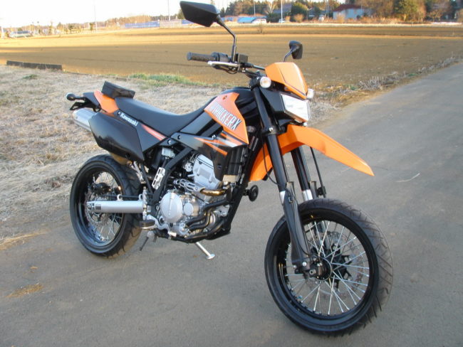 Мотоцикл Kawasaki D Tracker 250 в хорошем состоянии с оранжевыми накладками