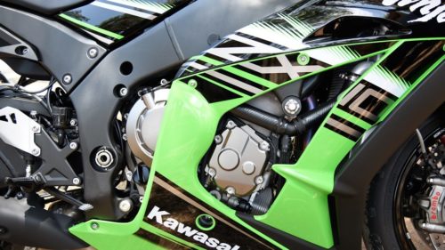 Четырехтактный мотор на раме мотоцикла Kawasaki Ninja ZX-10R, спрятанный за зелеными обтекателями