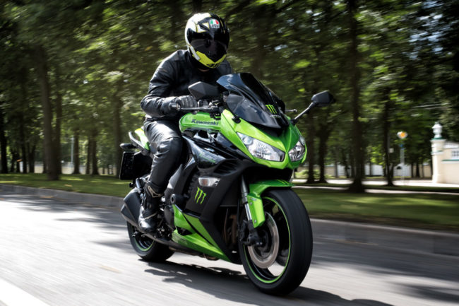 Езда по городу на дорожном байке Kawasaki Z1000 черно-зеленого цвета