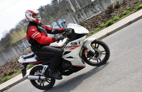 Байкер в красно-белом шлем за рулем мотоцикла Sagitta Spitzer SBR 150