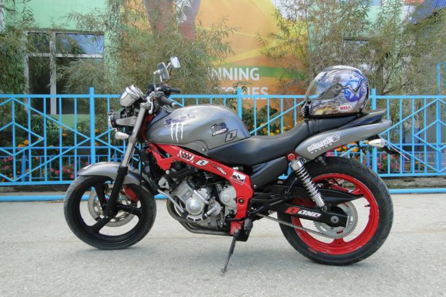 Серебристый шлем на сидение мотоцикла Yamaha FZX 250 Zeal с красным ободом заднего колеса