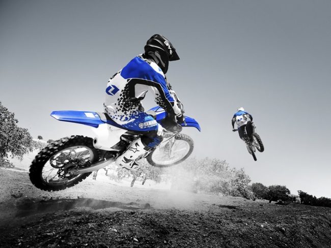 Прыжок на синем мотоцикле Yamaxa YZ450F во время трековых гонок