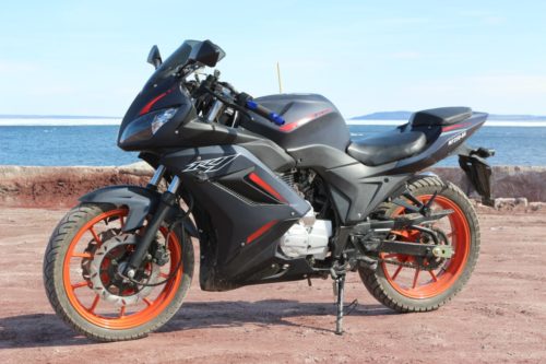 Вид сбоку мотоцикла Nanfang NF 250 черного цвета с оранжевыми дисками