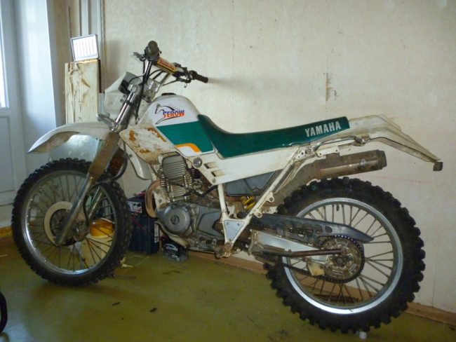 Потрёпанный Yamaha SEROW XT 225 стоит в гараже