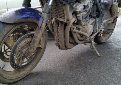 Обилие грязи на раме и двигателе мотоцикла Honda CB 400 после проката по грунтовой дороге