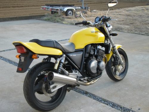 Вид сбоку желтого мотоцикла Honda CB 400 от японского производителя
