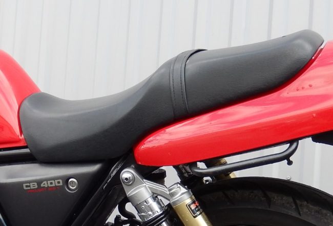 Длинное сдвоенное сидение на японском мотоцикле Honda CB 400 красного цвета