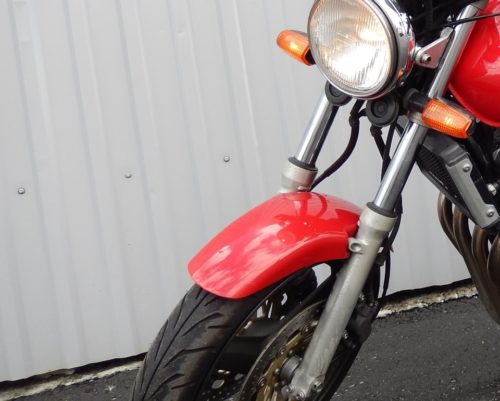 Передняя вилка телескопического типа на байке Honda CB 400 красного цвета