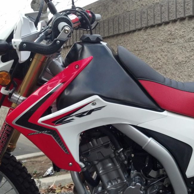 Красно-белый обтекатель и черный бензобак на мотоцикле Honda CRF 250