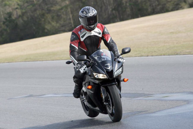 Мотогонщик среднего роста в шлеме на спорт-байке Honda CBR600RR