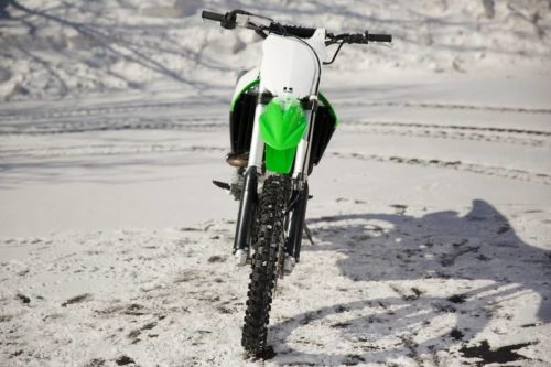 Фото японского мотоцикла Kawasaki KX450F на белом снегу