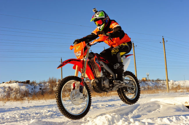 Прыжок на мотоцикле Xmotos XZ250 во время гонки по снежному треку