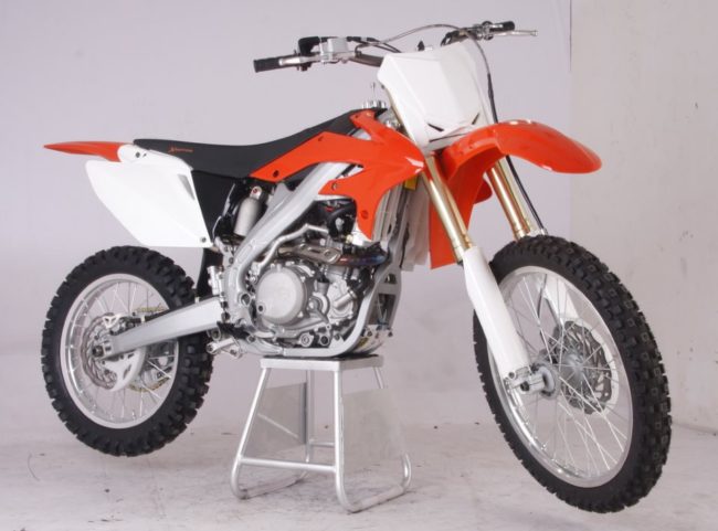 Вид сбоку кроссового мотоцикла Xmotos XZ250 оранжево-белой окраски