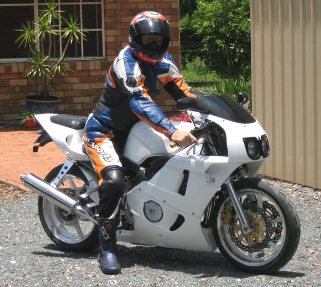 Удобная посадка гонщика среднего роста на байке Honda CBR400RR белого цвета