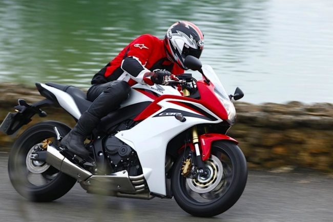 Красно-белый спорт-байк Honda CBR600F с мотогонщиком в шлеме