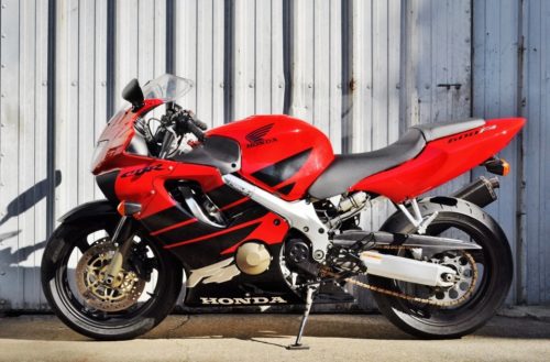 Вид сбоку мотоцикла спортивного класса Honda CBR600F красного цвета