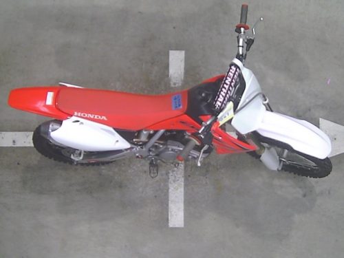Красное сидение на кроссовом мотоцикле Honda CRF150R