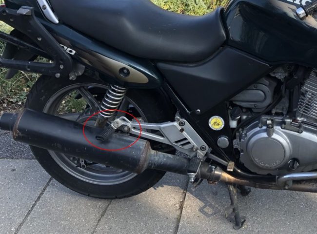 Подножка для заднего пассажира на мотоцикле Honda CB 500 с черным глушителем