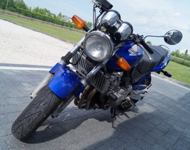 Передняя оптика круглой формы на синем мотоцикле Honda CB600 дорожного класса
