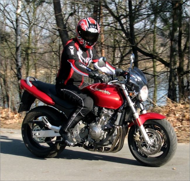 Удобная посадка мотоциклиста среднего роста на красном байке Honda CB600