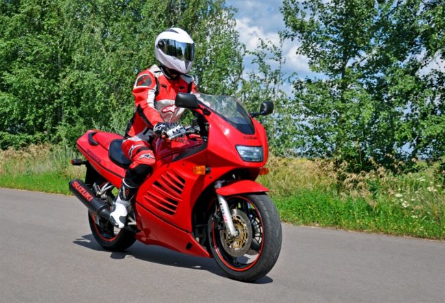 Удобная посадка мотоциклиста в красном комбинезоне на байке Suzuki RF 400