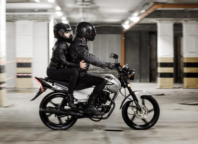 Парень с девушкой в черных комбинезонах на городском мотоцикле Зид 150
