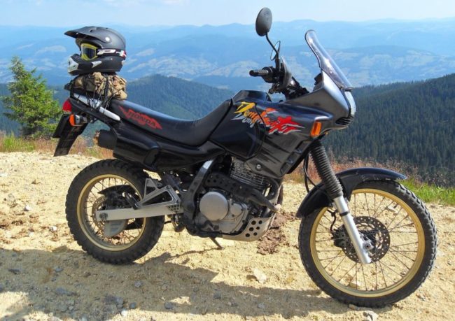 Мотоциклетный шлем на багажнике байка Honda NX 650 Dominator