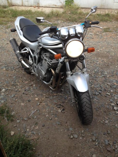 Включенный ближний свет в фаре мотоцикла Suzuki GSF 750 серебристой окраски