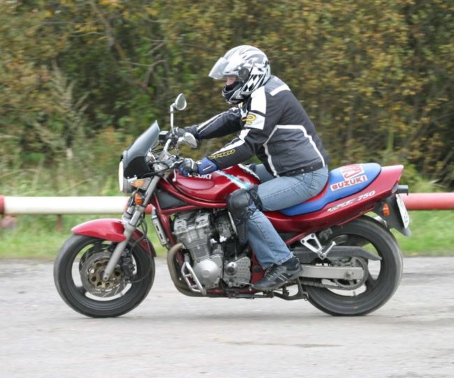 Посадка мотоциклиста среднего роста на байке Suzuki GSF 750 малинового цвета