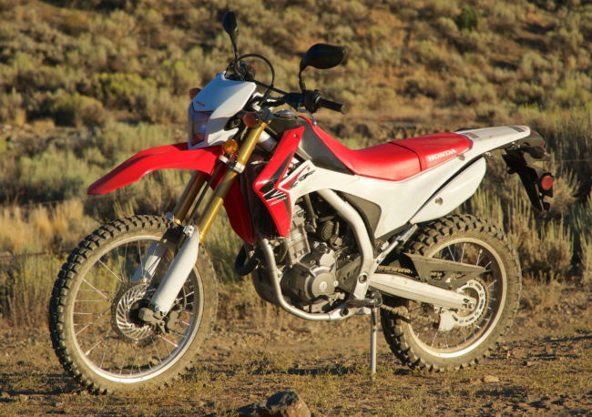 Вид сбоку японского мотоцикла Honda CRF250 версии L красно-белого цвета