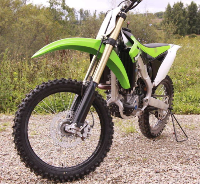 Крупный протектор на переднем колесе мотоцикла Kawasaki KX250F с зеленым крылом