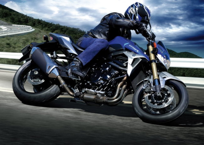 Байкер в шлеме и джинсах на мотоцикле Suzuki GSR 750 класса нейкед