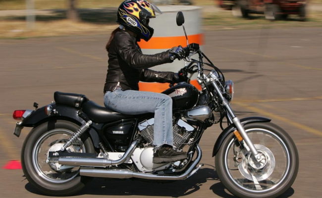 Девушка в джинсах и шлеме на популярном круизере Yamaha VIRAGO 250